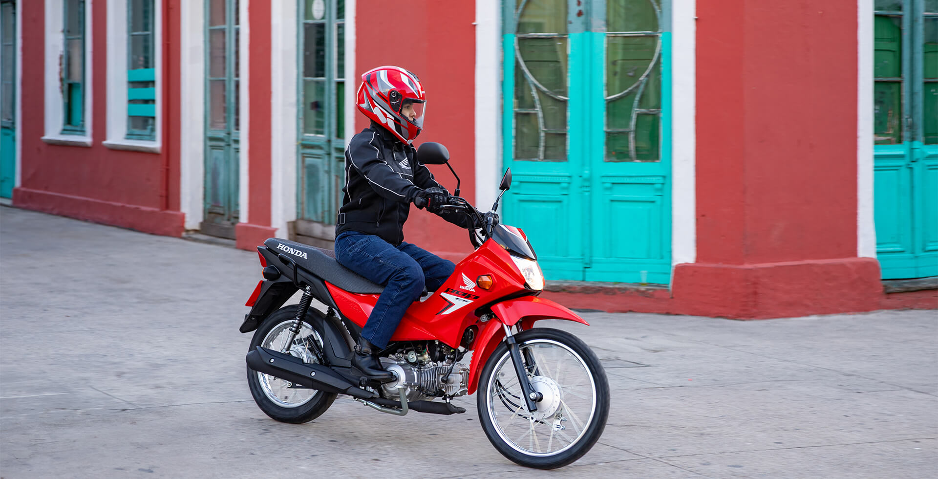 Piloto na cidade com sua Moto Honda POP 110i ES Vermelho Fighting Red