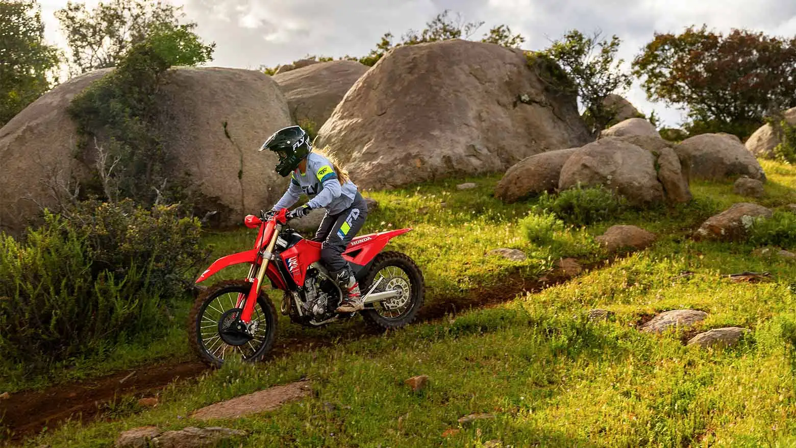  Mulher pilotando Moto Honda CRF 250 em cenário off road