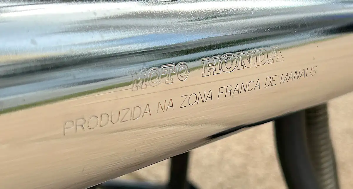 Detalhe do escapamento da moto Honda 125 ML, com gravação de produção