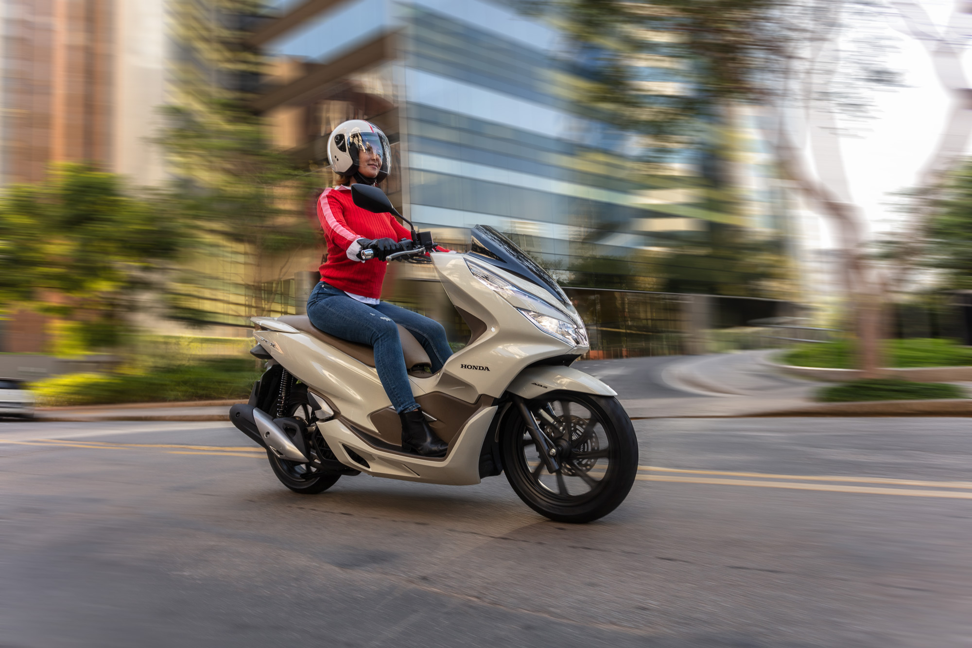 Mulher pilotando moto Honda Pcx em cidade