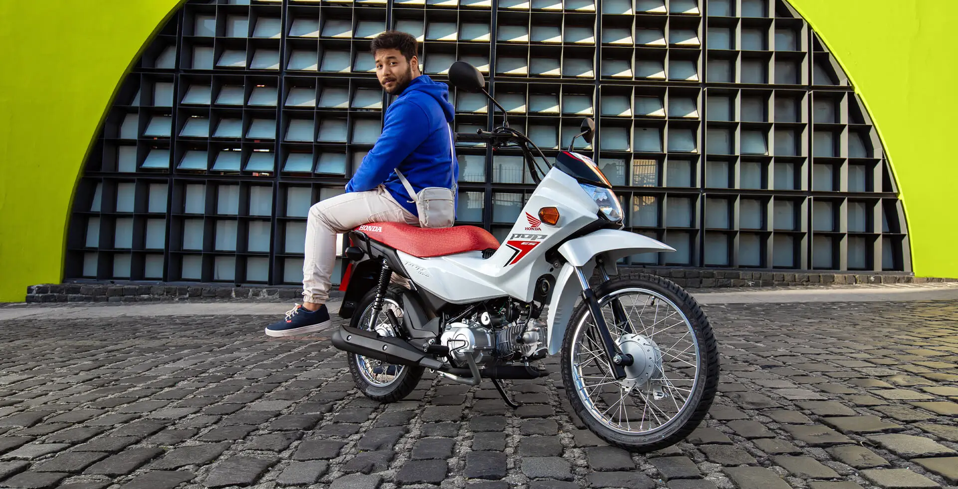Homem sentado na Moto Honda POP 110i ES Branco Ross White