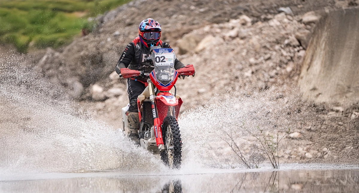 Martin Duplessis pilotando sua moto Honda em um trecho de água durante uma competição off-road