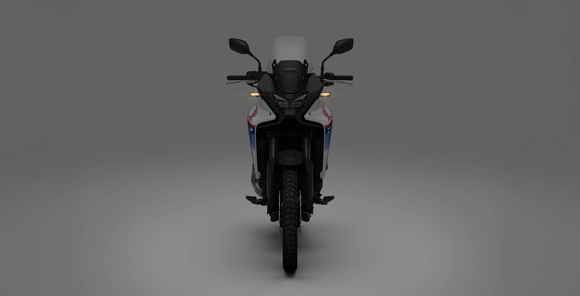 Moto Honda Transalp vista com iluminação baixa de frente 