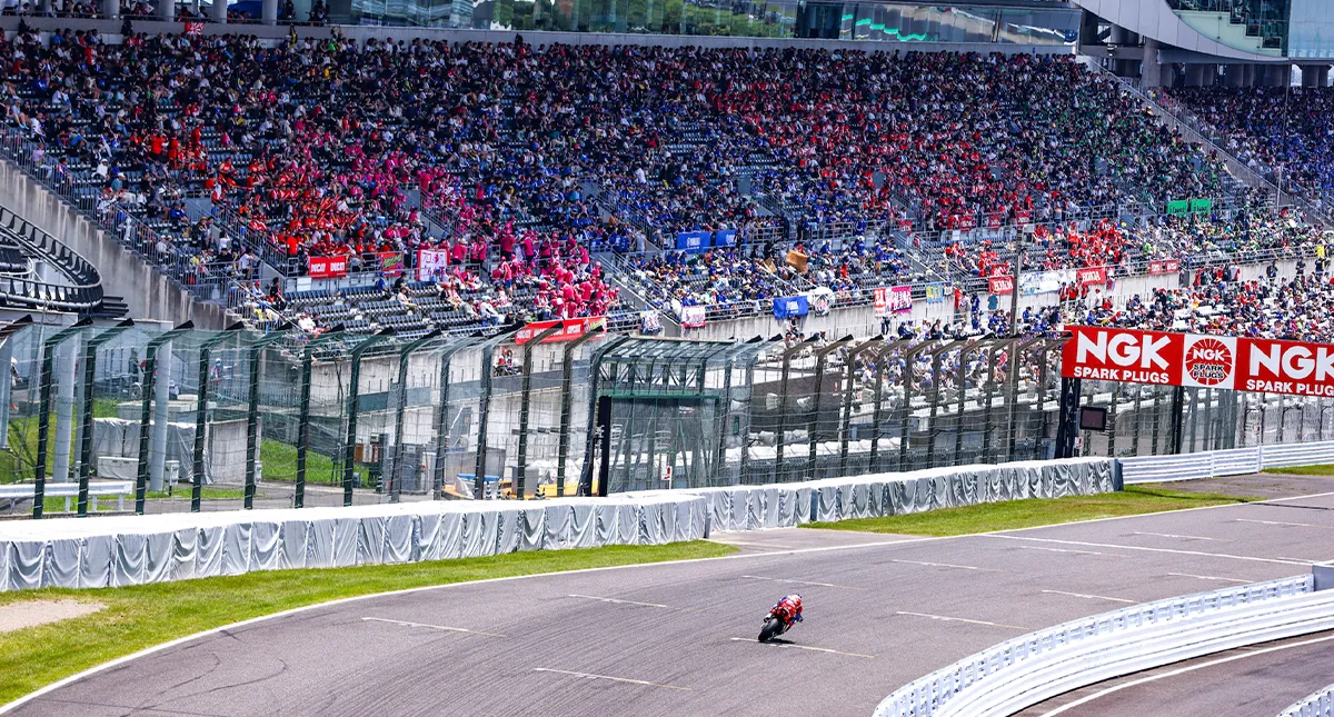 Piloto do Team HRC fazendo curva no campeonato Mundial de Endurance com platéia ao fundo