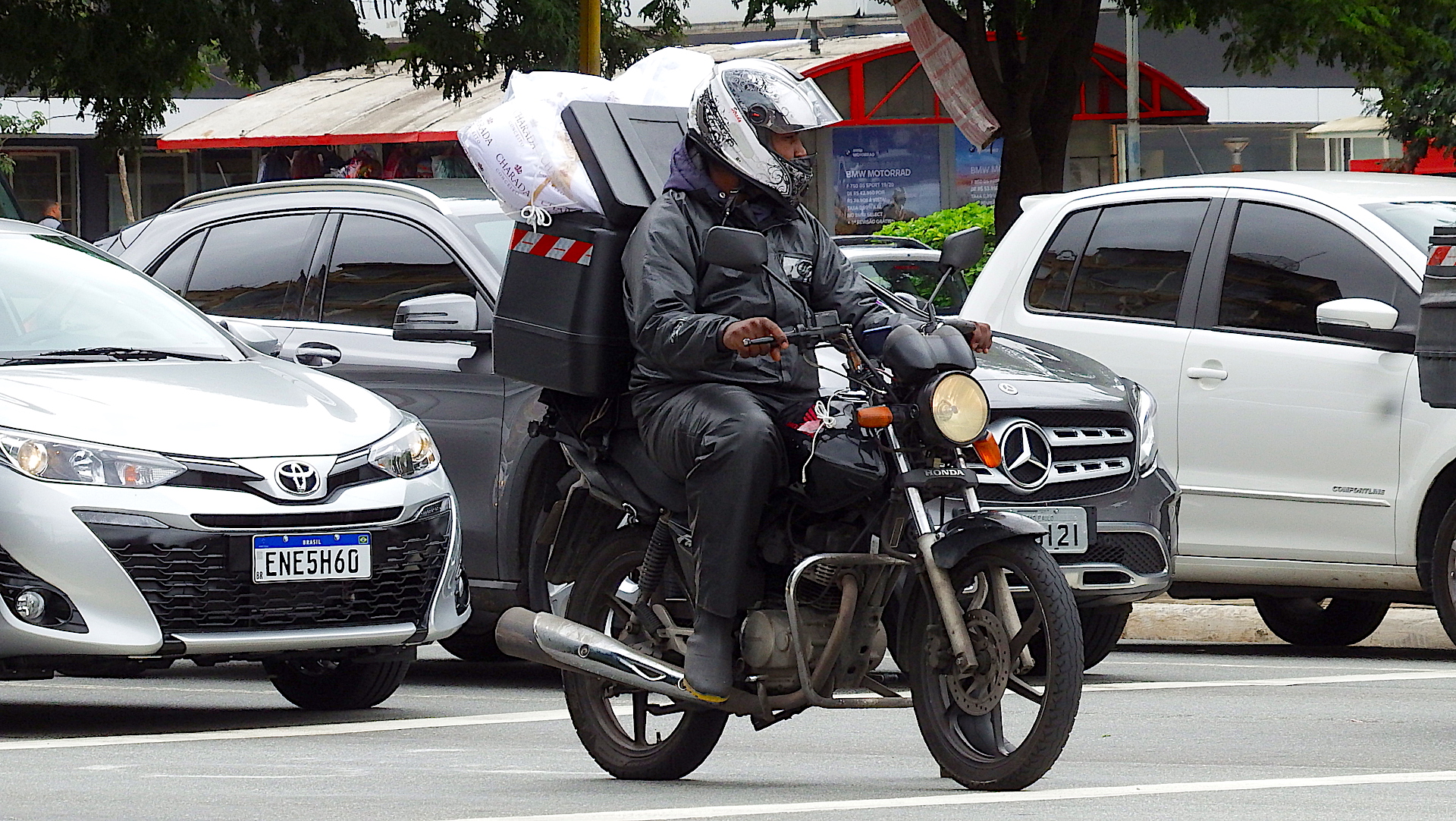 Motociclista em Moto Honda com Baú cheio