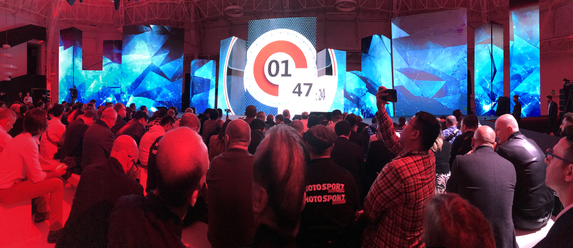 Pessoas olhando para o palco do salão de motos de Milão