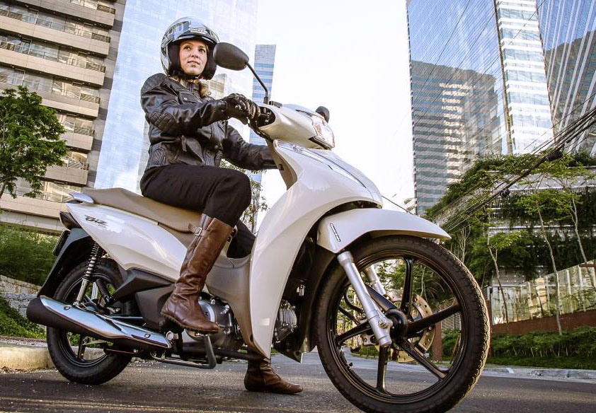 Mulher Sentada na Moto Honda Biz 125 Bege