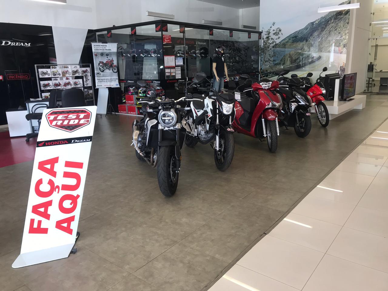 Motos enfileiradas em concessionária Honda com uma placa na frente escrito Test Ride faça aqui
