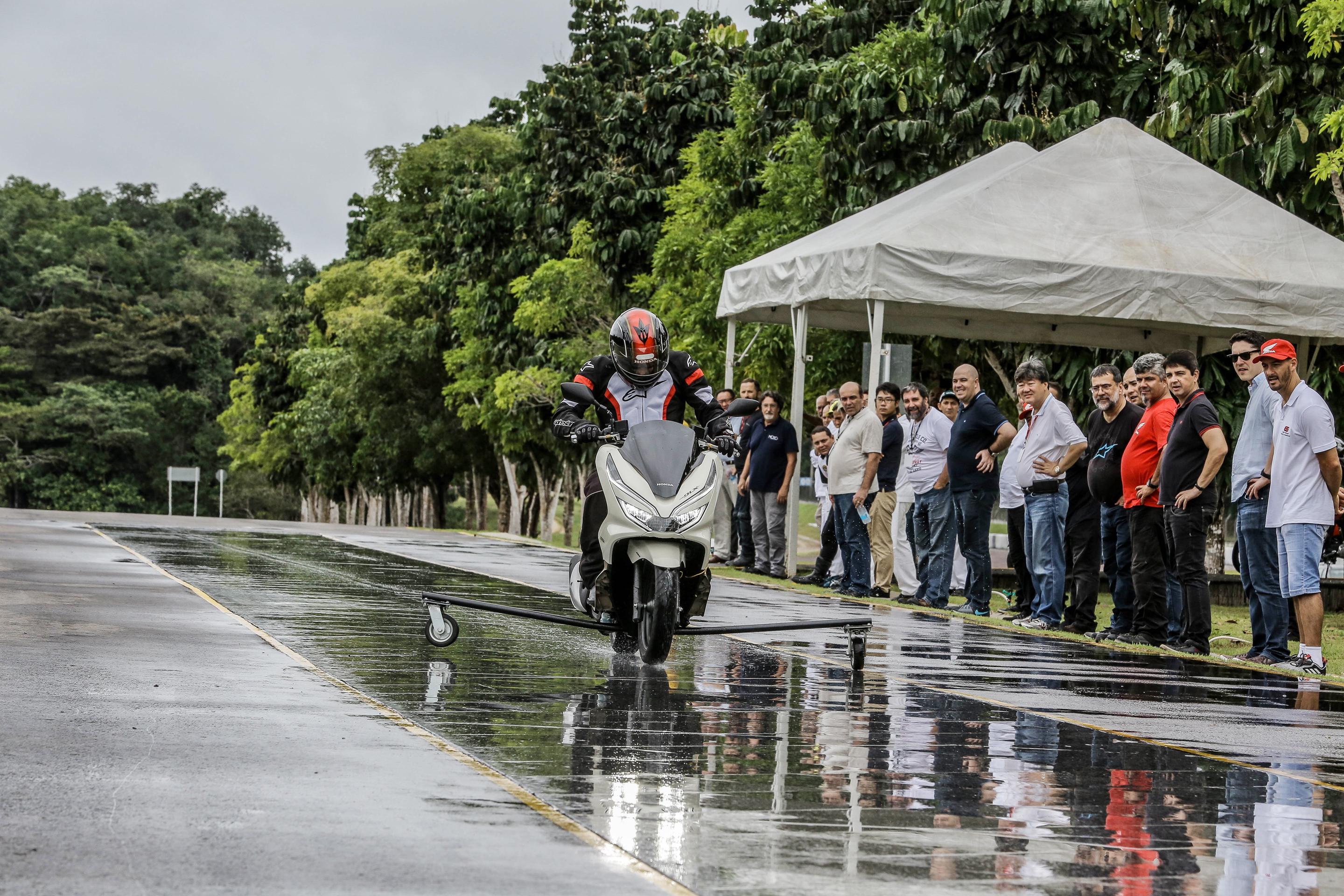 Piloto mostrando como frear scooter PCX em pista molhada