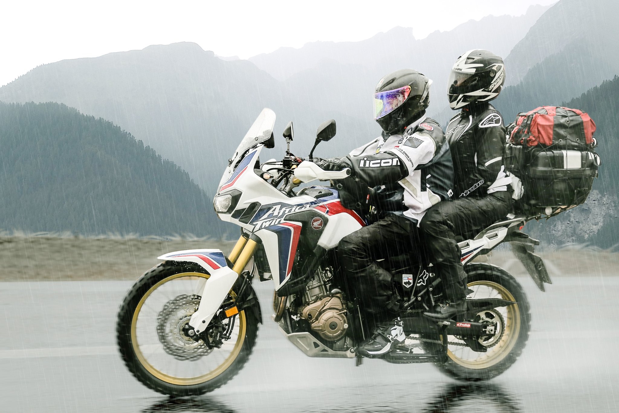 Casal fazendo viagem de moto em Africa Twin na chuva