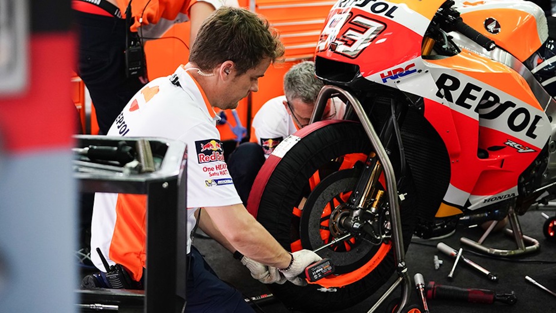 Mecânico com kit básico ajustando roda de moto Honda Repsol
