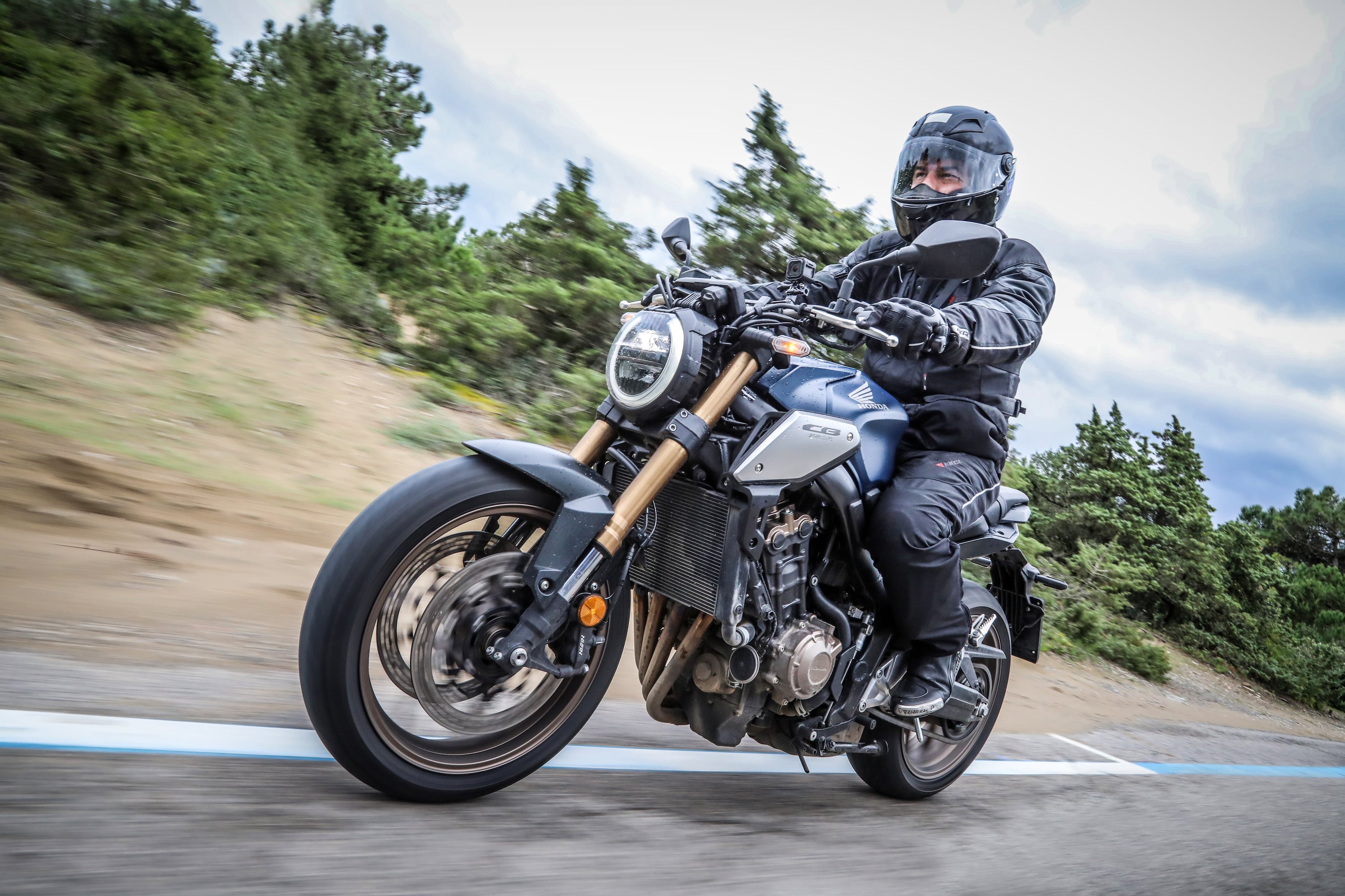 Piloto andando de moto Honda CB 1000R no frio