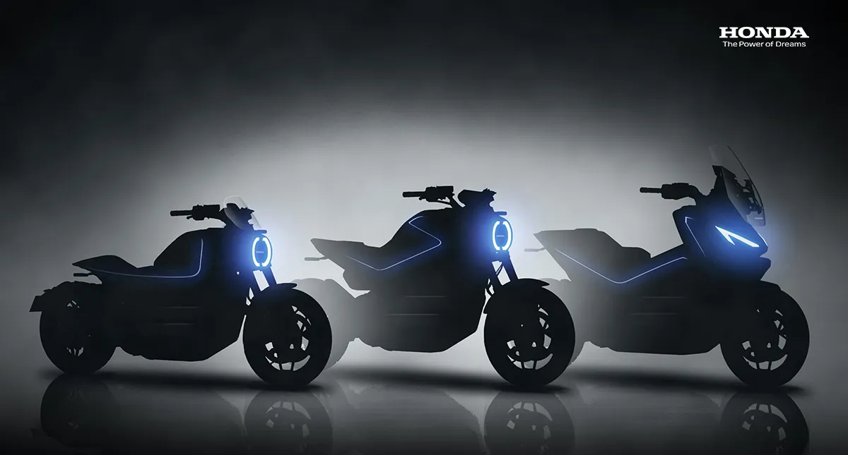 Foto com três motos elétricas da Honda com os faróis acesos