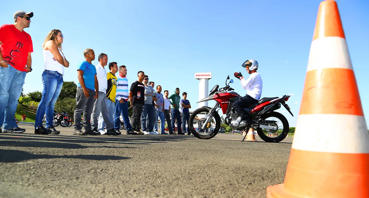 Instrutor em sua moto dando aula para alunos que irão tirar habilitação