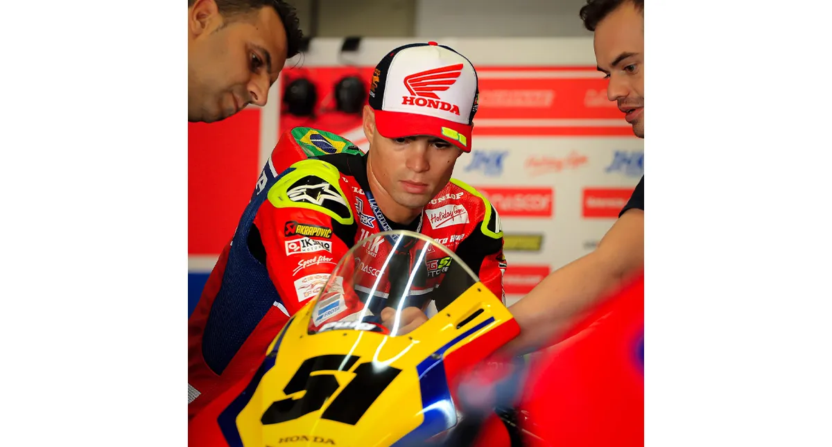 O piloto Eric Granado com sua Honda e dois membros da equipe