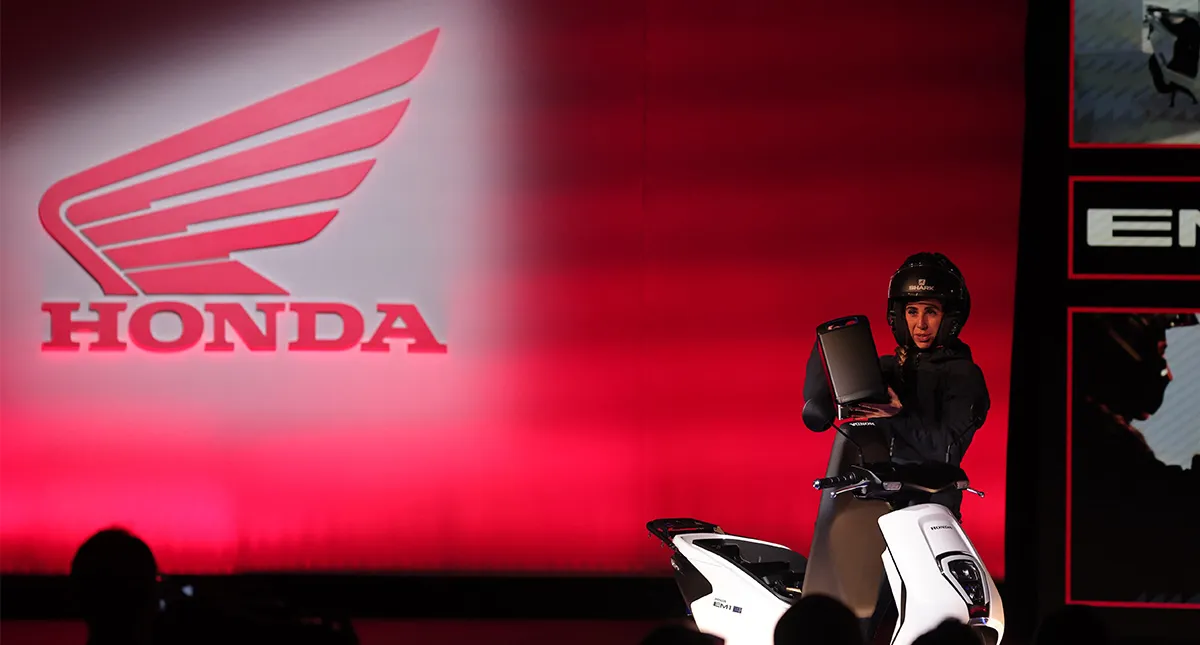 Motociclista mostrando bateria da Honda Em1 e