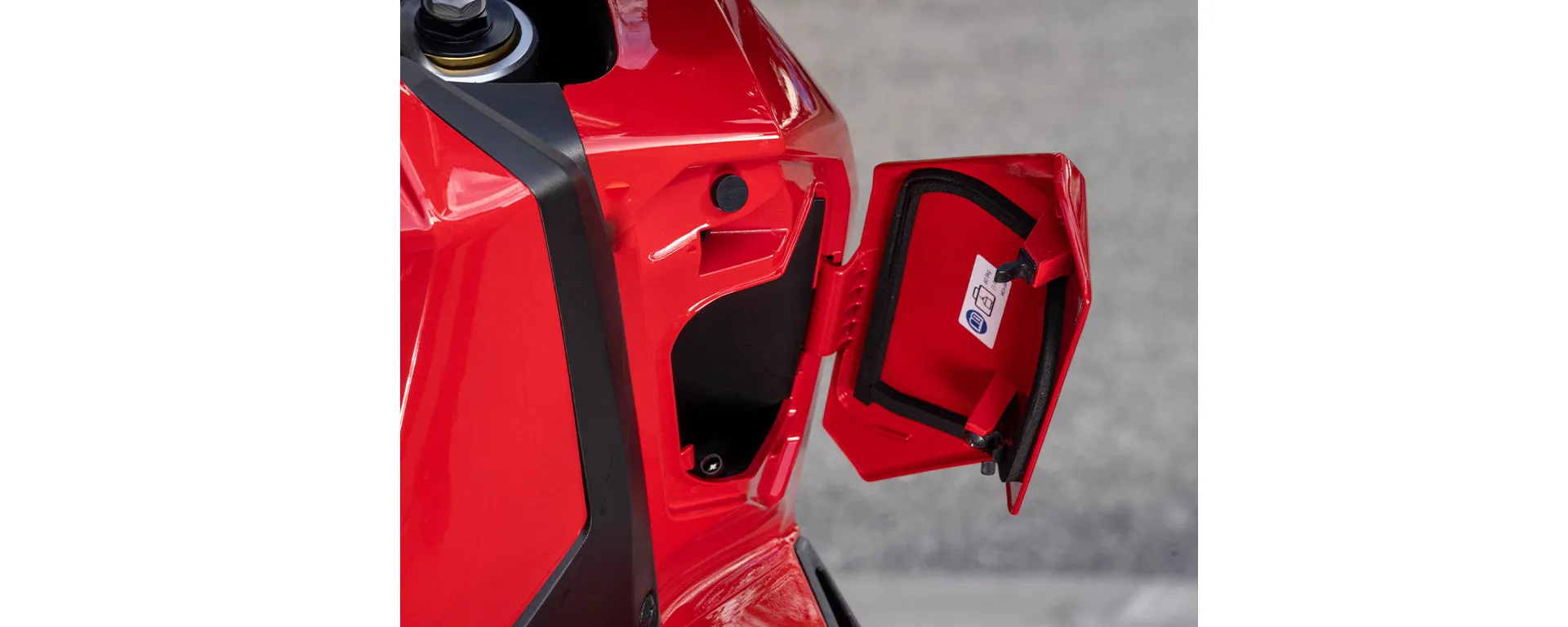 Compartimento porta-luvas embutido na carenagem dianteira da Moto Honda X-ADV Vermelha