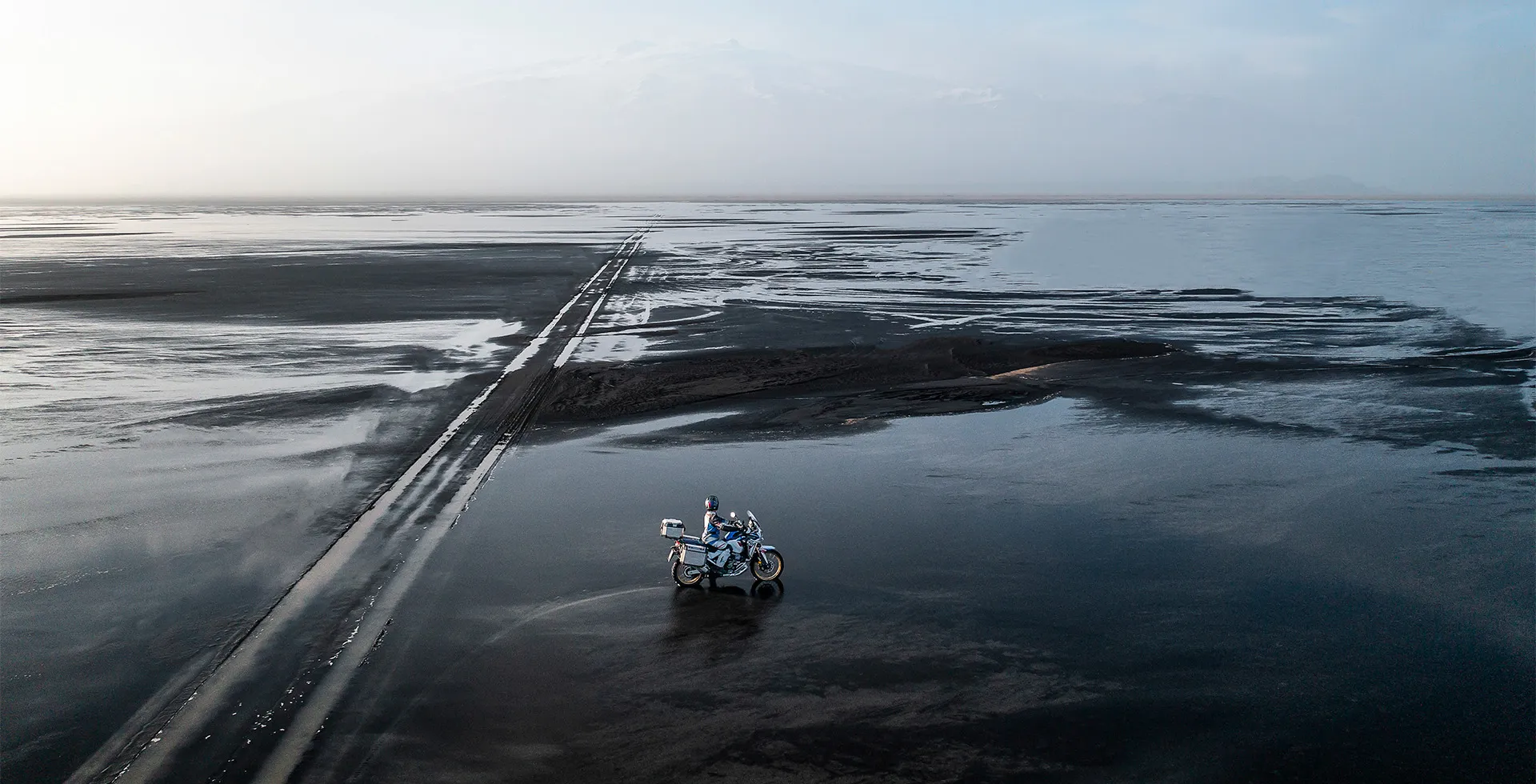 Piloto na Praia com Mar e Areia na Moto Honda CRF 1100L Africa Twin Adventure Sports
