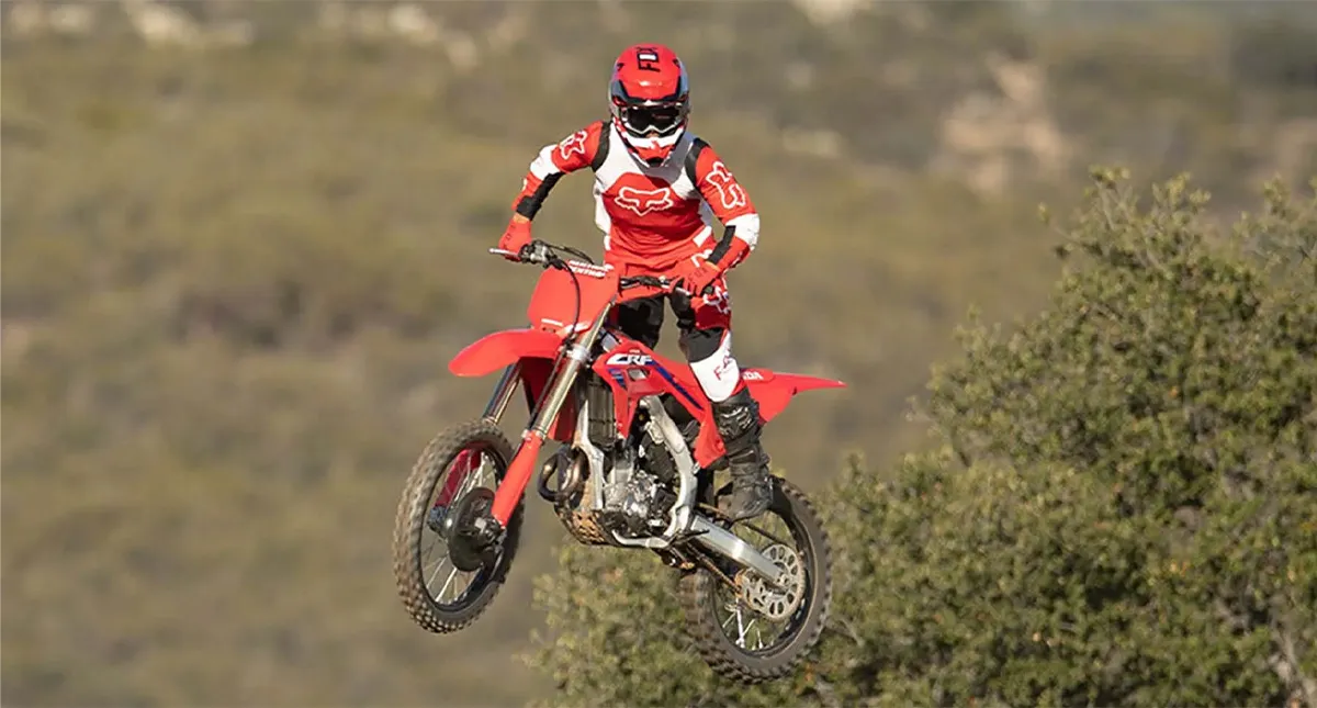 Piloto de Roupa Vermelha Saltando com Moto Honda CRF 250R Vermelha
