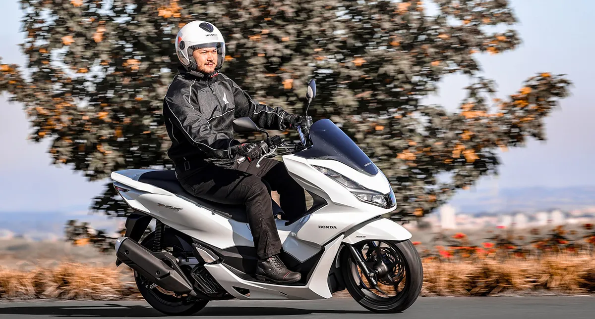 Motociclista pilotando sua Moto Honda PCX branca