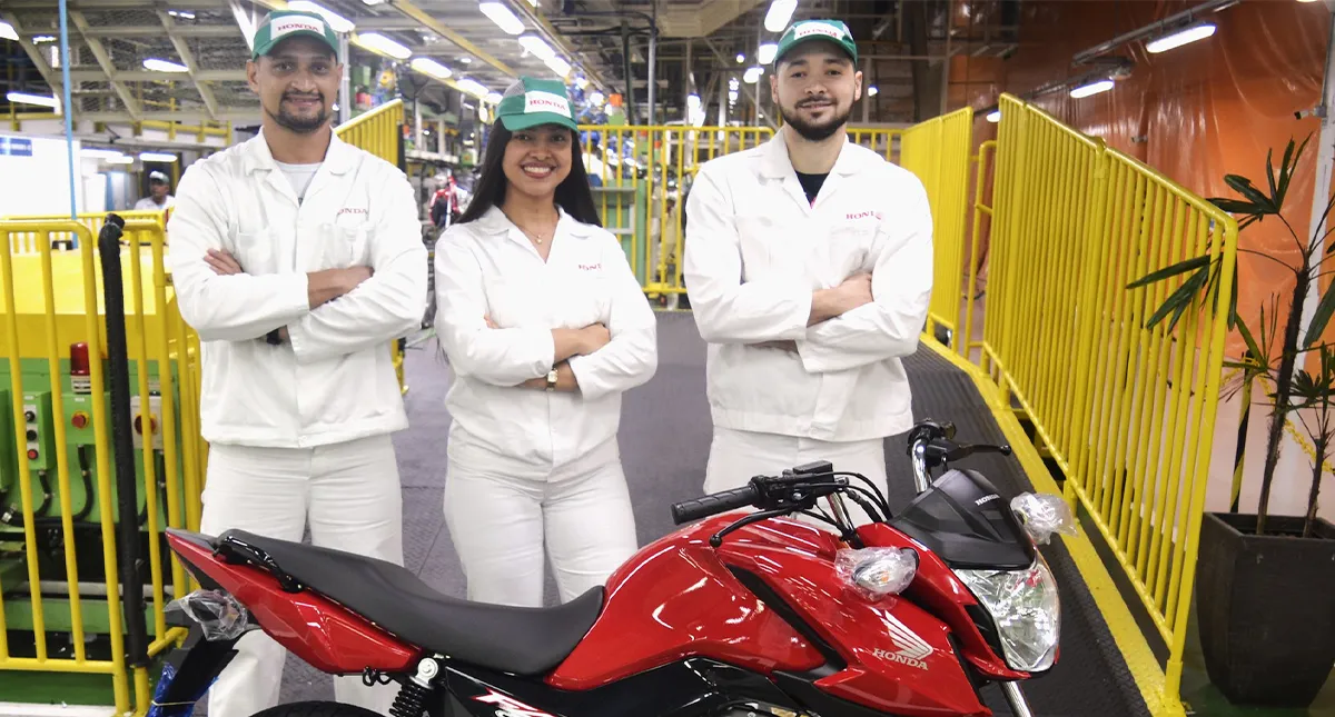 Três colaboradores da Honda, dois homens e uma mulher junto a CG 160 Titan