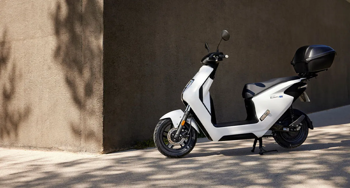 Honda EM1 e branca estacionada com baú