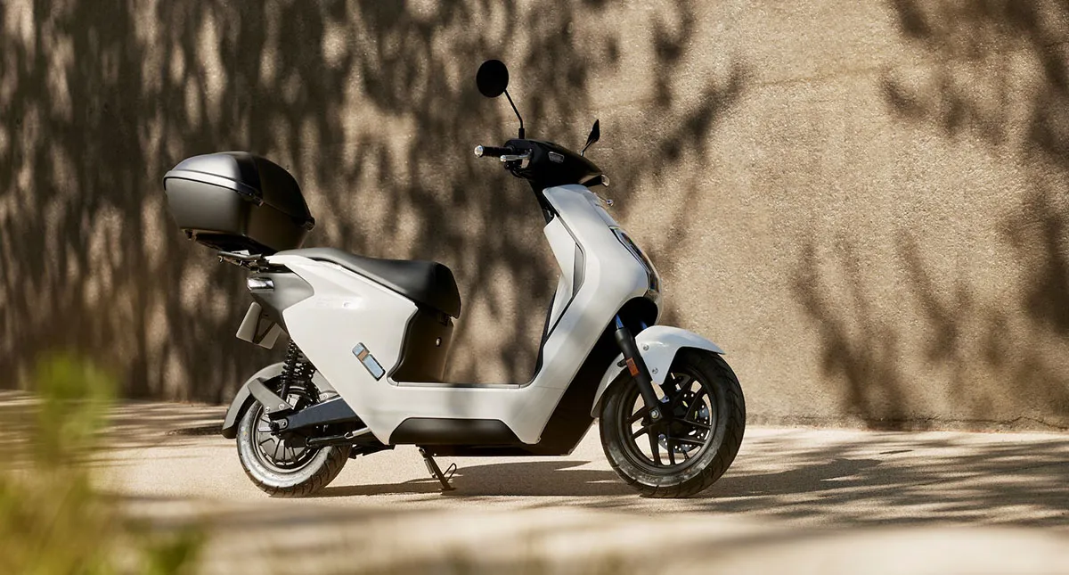 Honda EM1 e branca estacionada