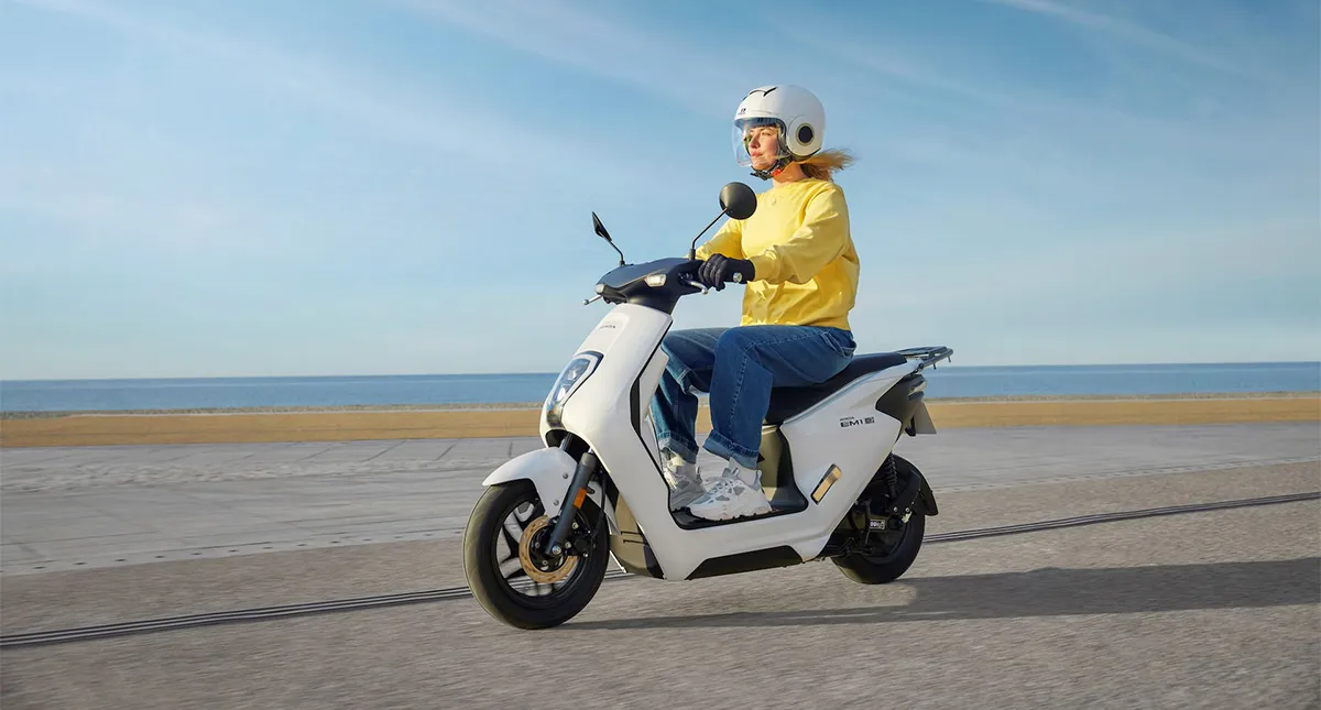 Mulher pilotando sua Scooter elétrica Honda EM1 e