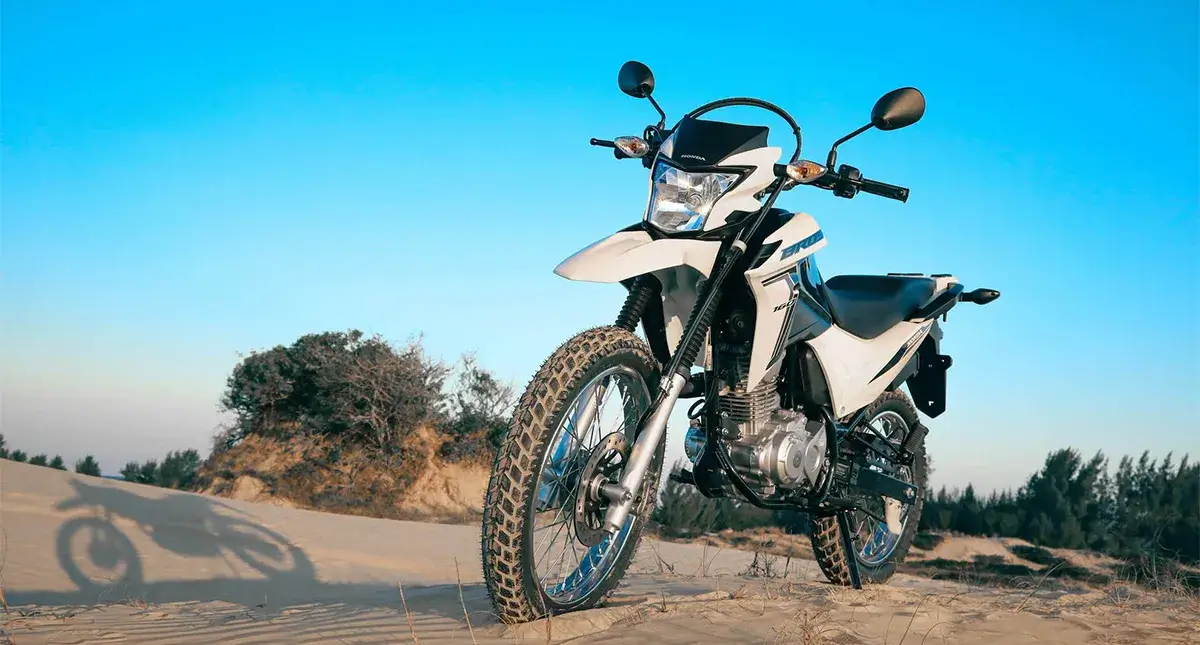Moto Honda NXR 160 Bros Branca Estacionada na areia da Praia