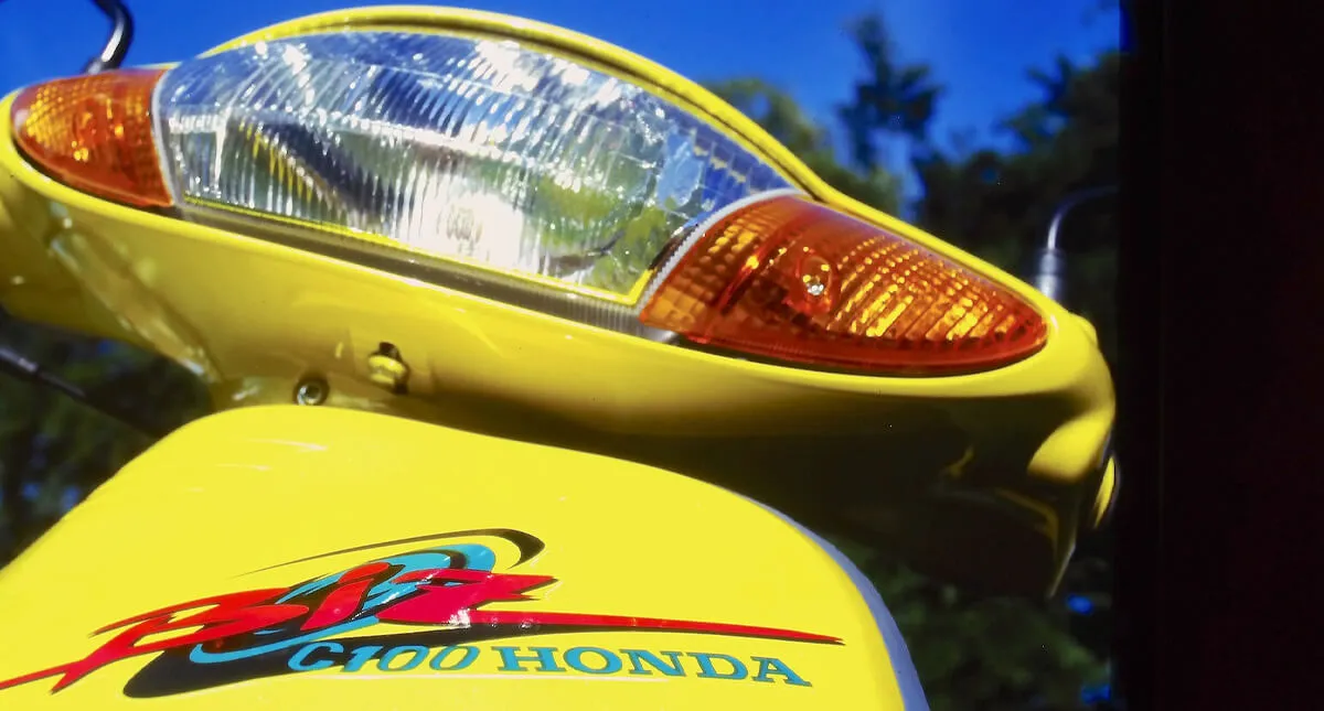 Detalhe Farol da Motocicleta Honda C100 Biz Amarela 