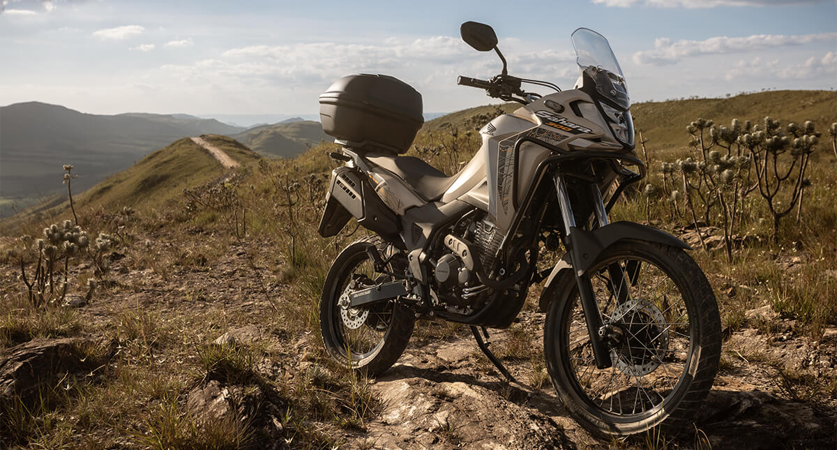 Moto Honda Sahara 300 com paisagem de montanhas ao fundo