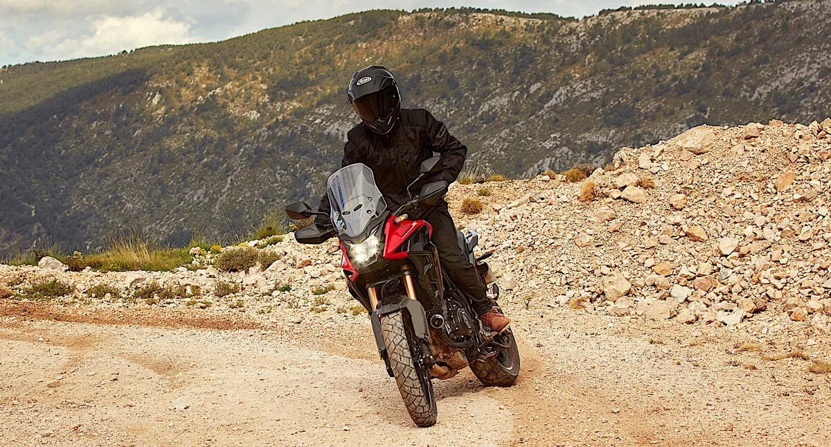 Piloto com Honda CB 500X em estrada de terra