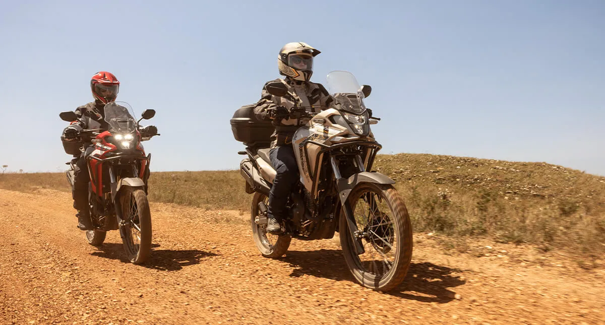 Pilotos em estrada de terra com as motocicletas Honda Sahara 300 Adventure e Rally
