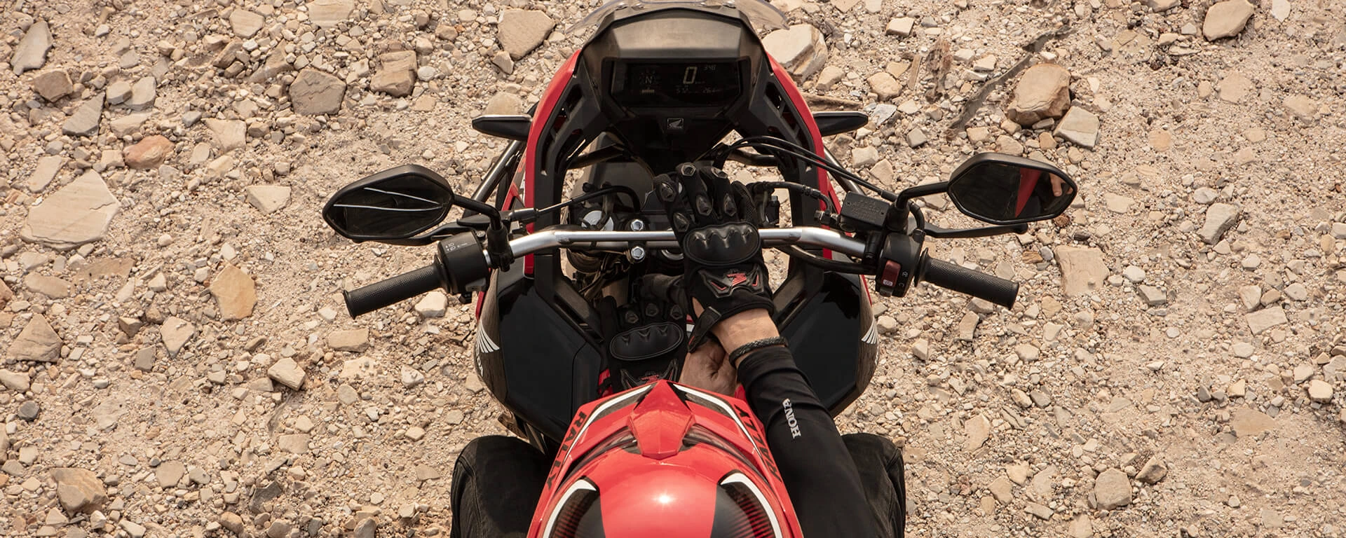 Vista de cima de piloto com a mão na estrada USB-C da moto Honda Sahara 300