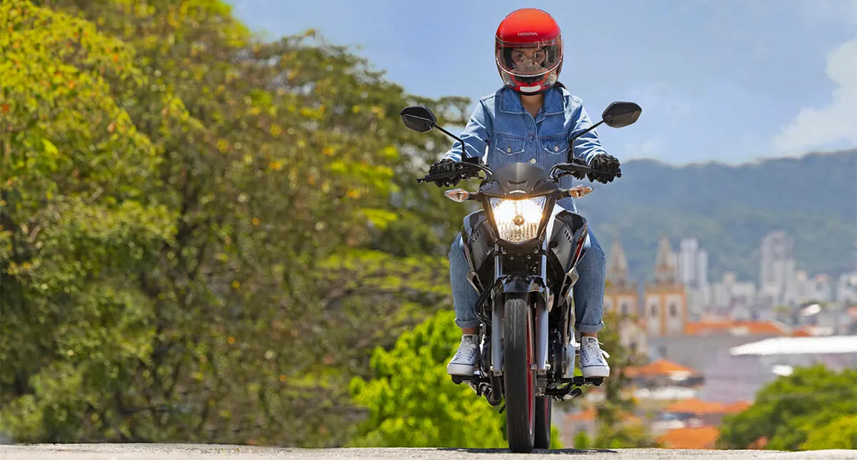 Motocicleta Honda CG Titan com motociclista na estrada