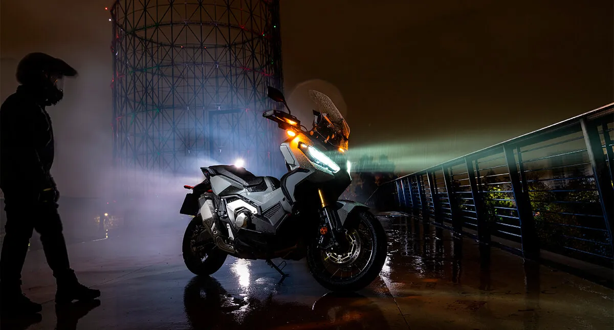 Motocicleta Honda X ADV 2023 com iluminação em modo noturno 