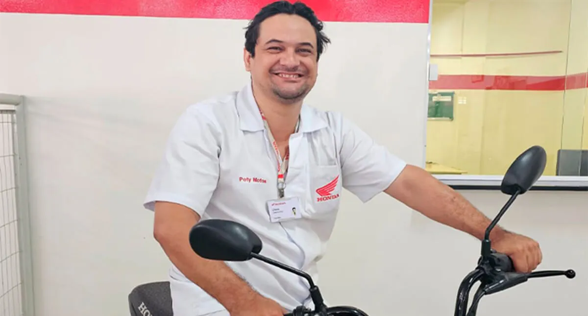 Mecânico Clécio Vieira Sorrindo Sentado em Motocicleta Honda