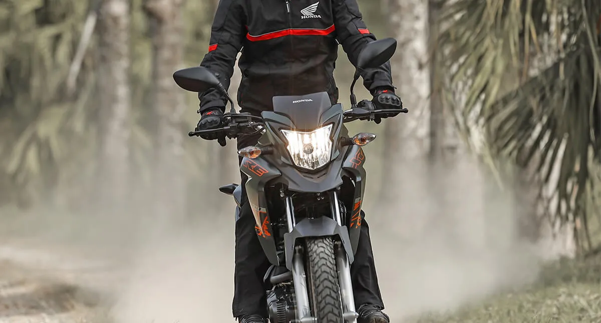 Homem pilotando sua Honda XRE 190 em estrada de terra