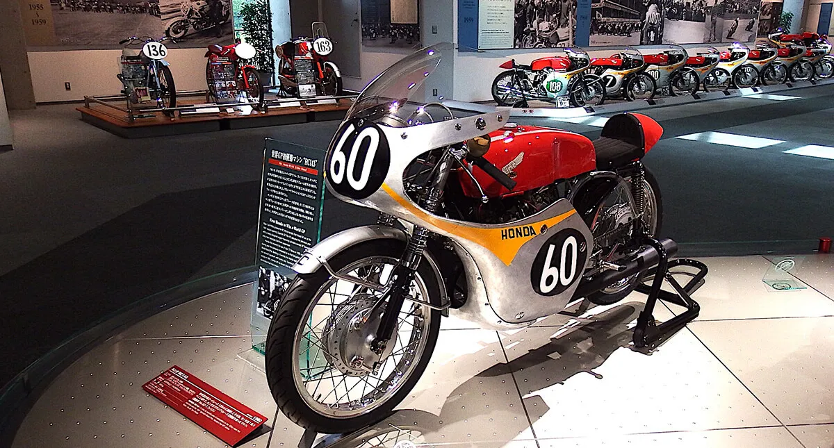 Motocicleta Honda RC143 de 1961 vermelha com prata em exposição