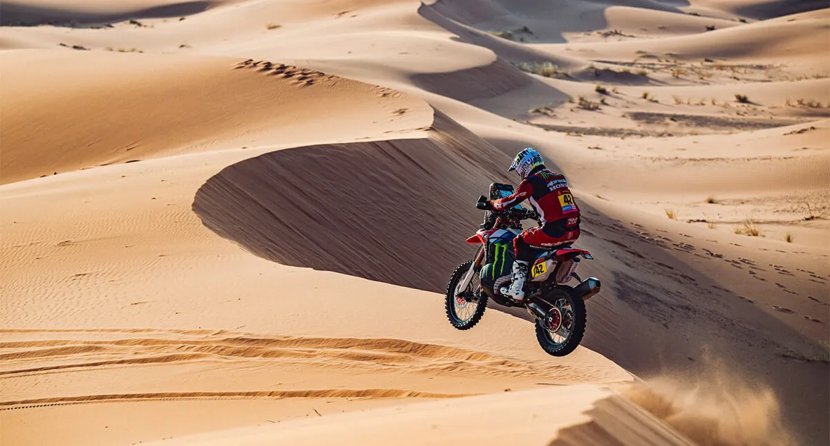 Piloto Honda saltando em duna de areia no Rally Dakar 2024