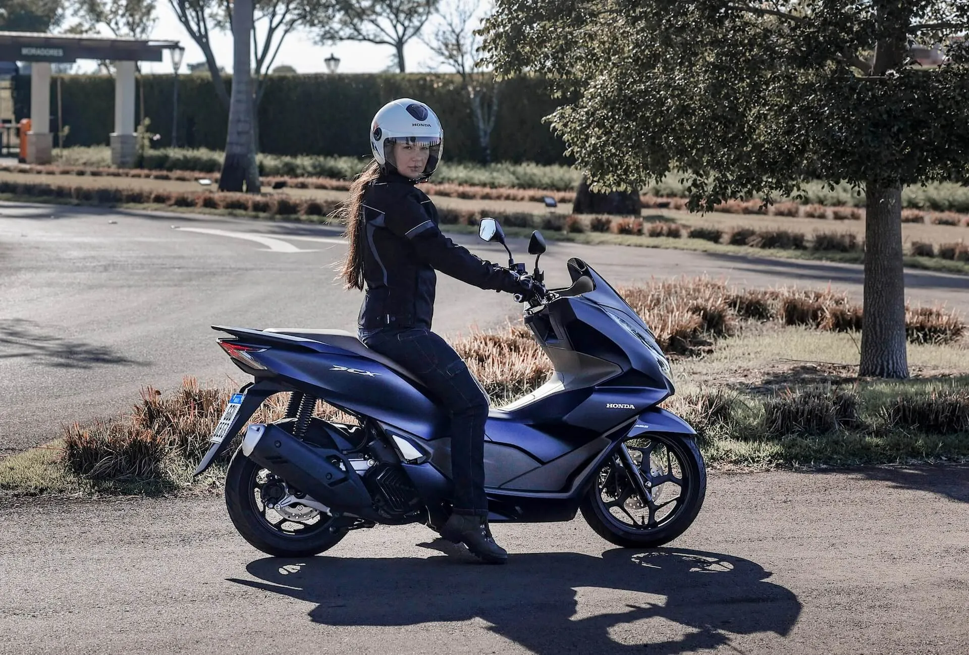 Mulher em sua Honda PCX azul metálico