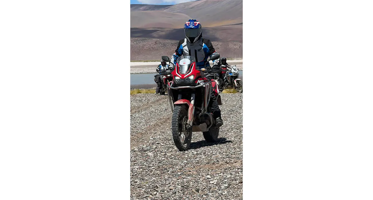 Piloto em sua Honda CRF 1100L Africa Twin e demais pilotos atrás