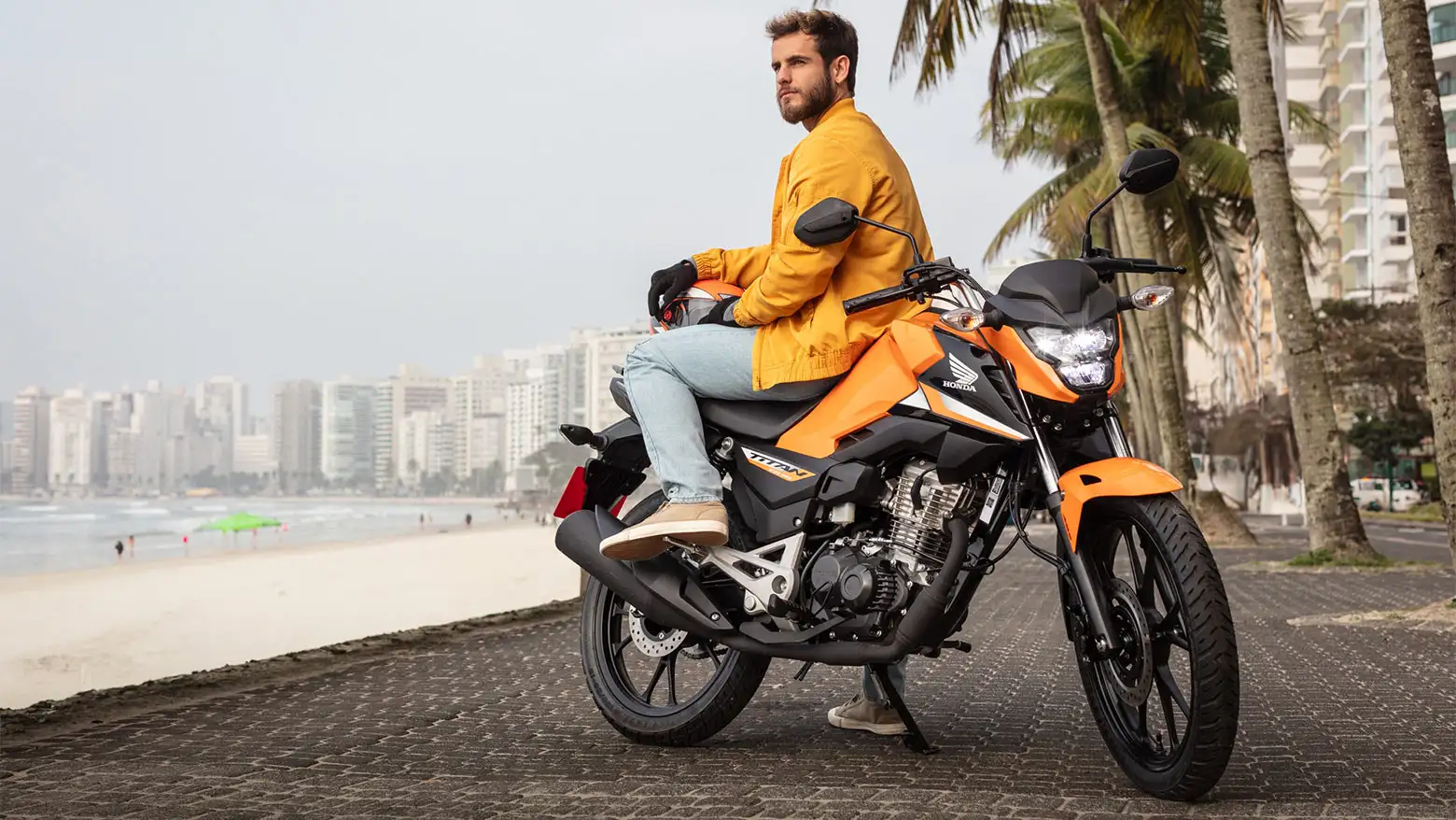 Homem observando a paisagem sentado na Honda CG-160 Titan Laranja