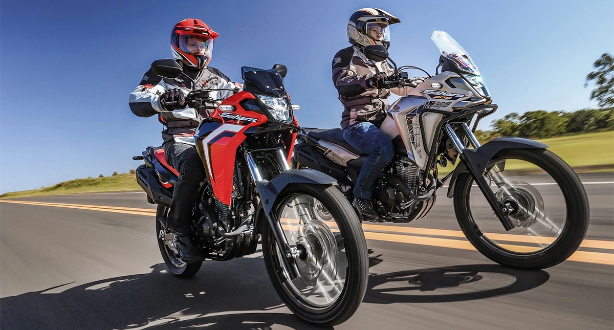 Dois motociclistas pilotando a Honda XRE 300 Sahara em uma estrada aberta