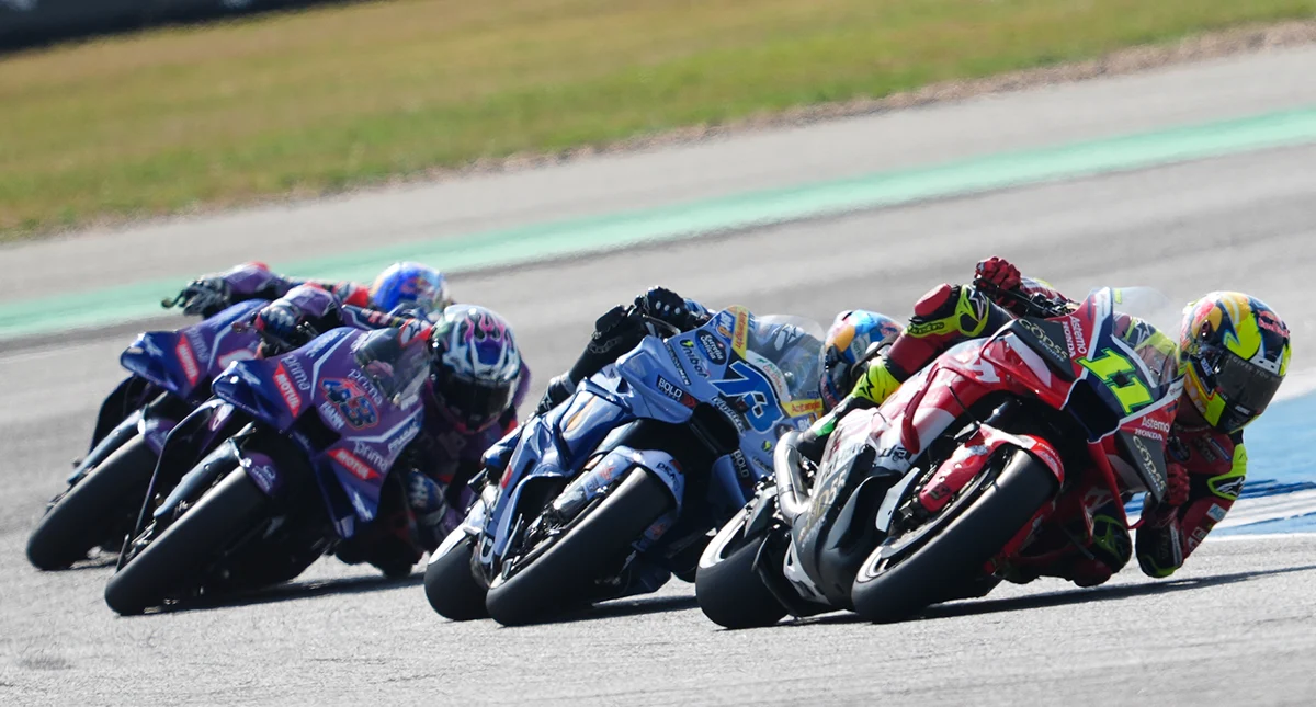 Pilotos fazendo curva fechada em motos de corrida