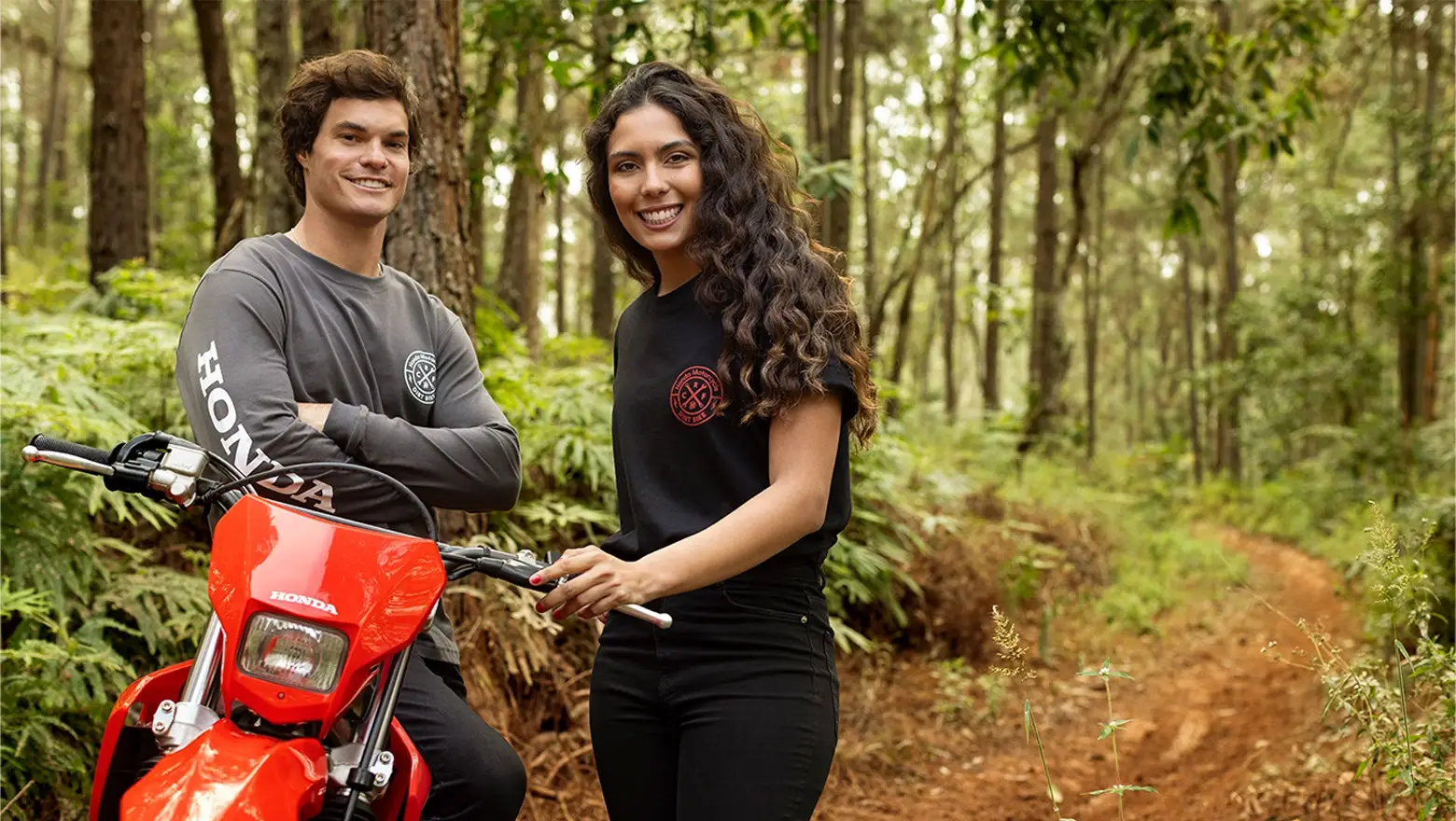 Honda CRF300F na floresta com dois pilotos