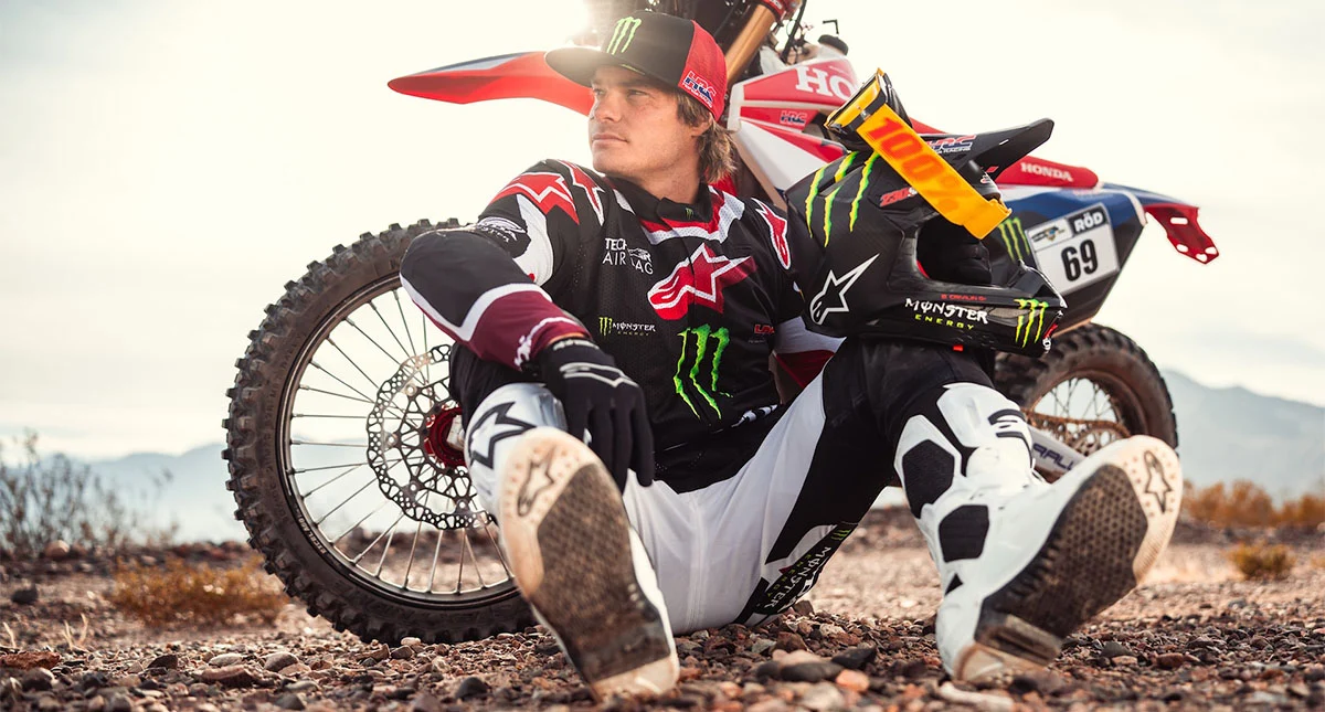 Bruno Crivilin pousando pra foto com moto honda atrás