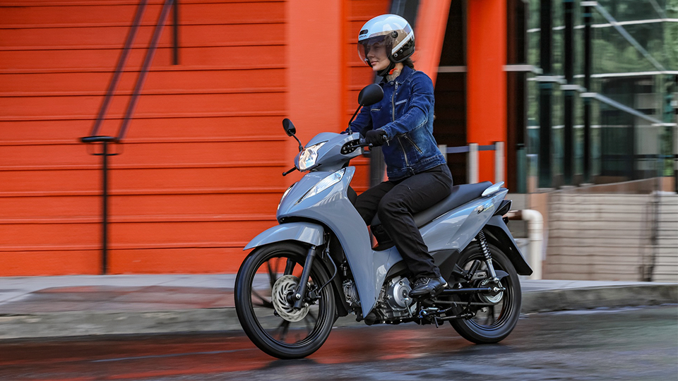 mulher pilotando uma Biz 125