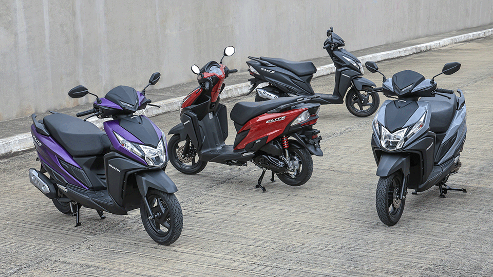 Quatro scooters de cores diferentes estacionadas